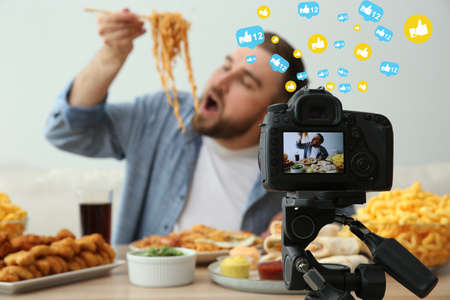 Food blogger recording eating show against light background, focus on camera screen. mukbang vlog