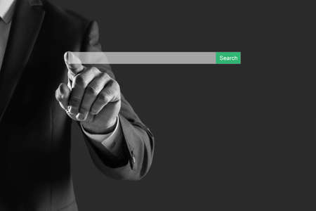 Businessman using search bar of website on virtual screen, closeup. black and white photo