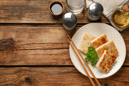 Delicious turnip cake with parsley served on wooden table, flat lay. Space for textの写真素材
