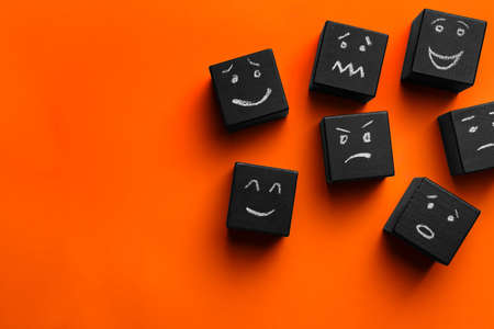 Many cubes with different emotions on orange background, flat lay and space for text. Emotional managementの写真素材