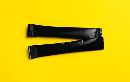 Black sticks of sugar on yellow background, flat layの写真素材