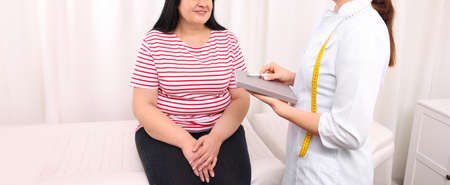 Overweight mature woman consulting with nutritionist in clinic, closeup. banner designの写真素材