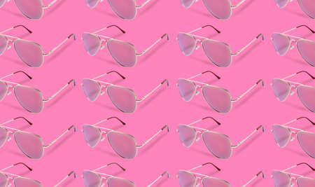 Many stylish sunglasses on pink background. Seamless pattern designの写真素材