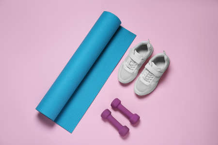 Exercise mat, dumbbells and shoes on pink background, flat layの写真素材
