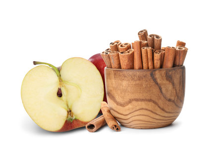 Fresh ripe apples and aromatic cinnamon sticks on white backgroundの写真素材