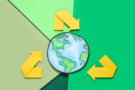 Recycling symbol and paper planet on color background, flat lay