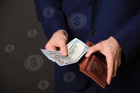 Businessman with wallet and dollar bills on dark background, closeup