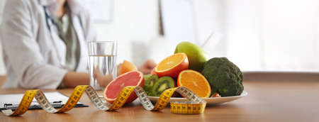 Healthy products, measuring tape and blurred nutritionist on background. banner designの写真素材
