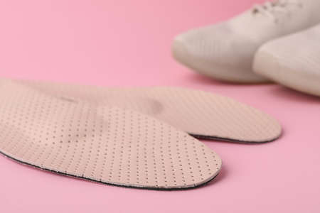 Orthopedic insoles and shoes on pink background, closeupの写真素材