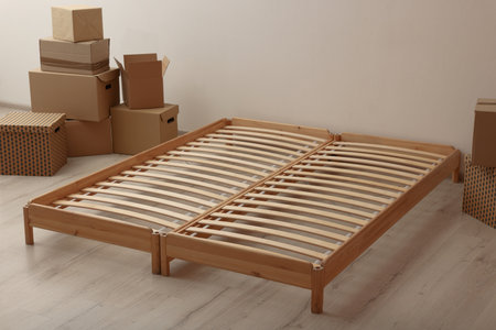 Wooden bed frame and cardboard boxes on floor in room