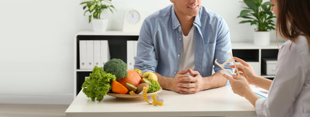 Young nutritionist consulting patient at table in clinic, closeup. banner designの写真素材