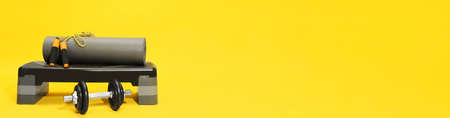 Step platform, dumbbell, mat and jump rope on yellow background, space for text. banner design