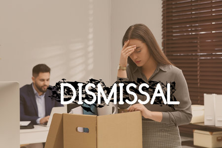 Dismissed woman packing personal stuff into box in officeの写真素材