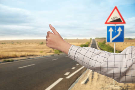 Woman catching car on road, closeup. Hitchhiking tripの写真素材