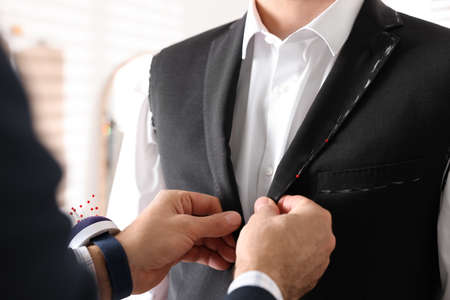 Professional tailor working with client in atelier, closeupの写真素材