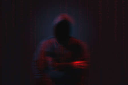Silhouette of anonymous hacker and digital binary code on dark background. cyber attack concept