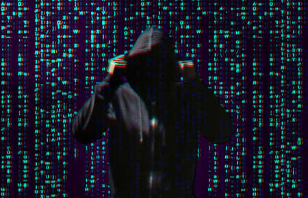 Silhouette of anonymous hacker and digital binary code on dark background. cyber attack concept