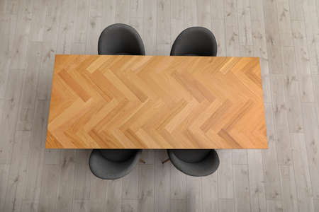 Wooden table and gray chairs indoors, top view