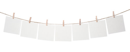 Clothespins with empty notepapers on string against white background. Space for text