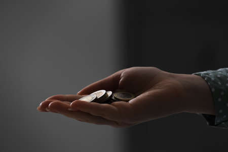 Woman holding coins on blurred background, closeup. money saving