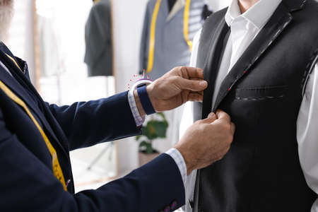 Professional tailor working with client in atelier, closeupの写真素材