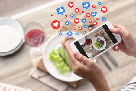 Blogger taking photo of food with mobile phone, closeup