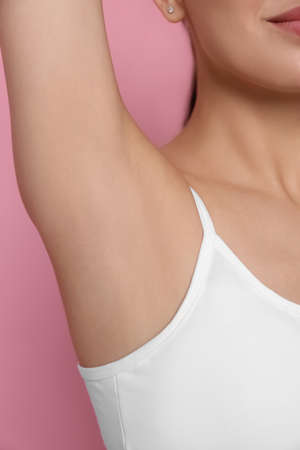 Young woman showing smooth skin after epilation on pink background, closeupの写真素材