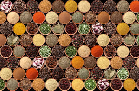 Collection of different aromatic spices and herbs on black background, flat layの写真素材