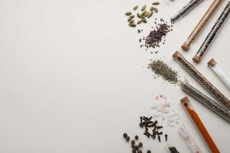 Test tubes with various spices on white background, flat lay. Space for textの写真素材