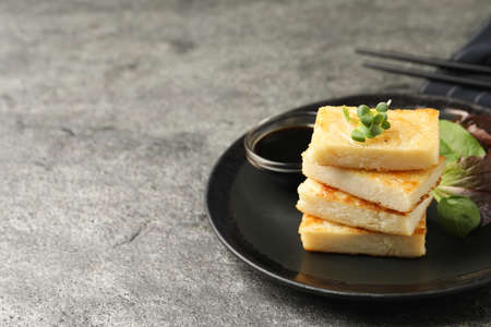 Delicious turnip cake with herbs served on gray table. Space for textの写真素材