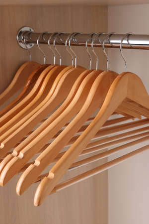 Set of clothes hangers on wardrobe rail, closeup