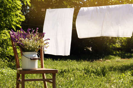 Beautiful bouquet with field flowers on chair outdoors, space for text
