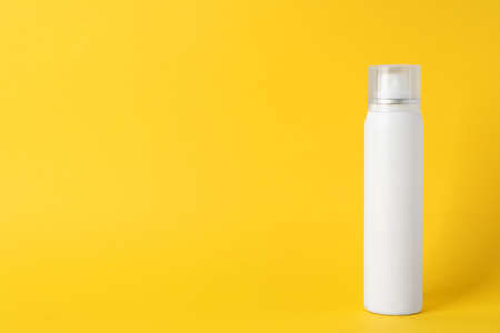 Bottle of dry shampoo on yellow background, space for textの写真素材