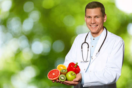 Nutritionist with fresh products on blurred green backgroundの写真素材