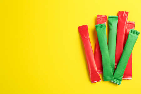 Different sticks of sugar on yellow background, flat lay. Space for textの写真素材