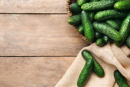 Fresh ripe cucumbers on wooden background, flat lay. Space for textの写真素材