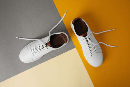 Pair of stylish white sneakers on color background, flat lay
