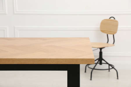 Wooden table with office chair in the room