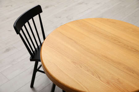 Stylish round table with black chair on floorの写真素材