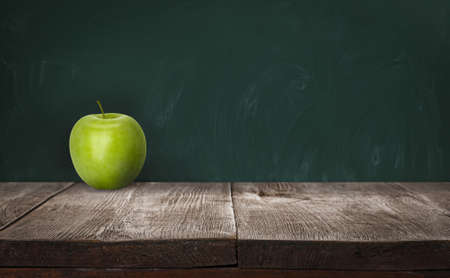 Fresh ripe green apple on wooden table near chalkboard, space for textの写真素材