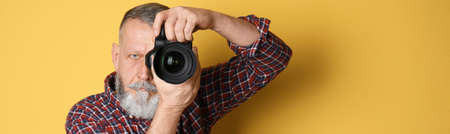 Professional photographer with camera on yellow background, space for text. banner designの写真素材