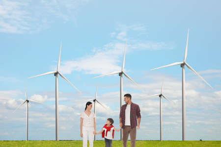 Happy family with child and view of wind energy turbinesの写真素材