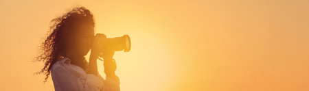 African American photographer taking photo with professional camera outdoors at sunset, space for text. banner designの写真素材