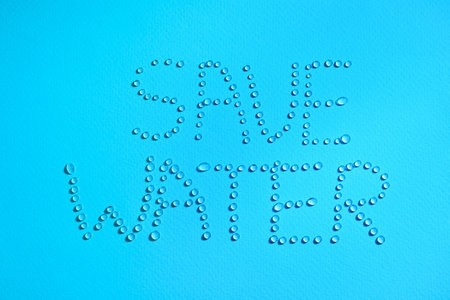 Inscription Save Water made of drops on light blue background, top viewの写真素材