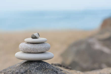 Stack of stones on rock near sea, space for text