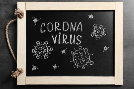 Blackboard with word Coronavirus on gray table, top viewの写真素材