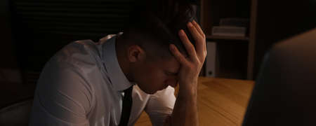 Tired businessman stressing out at workplace late in the evening. banner design