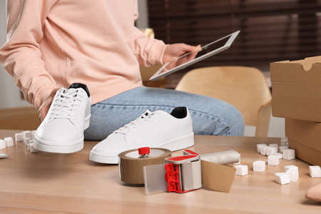 Shoes seller working with tablet in office, closeup. online storeの写真素材