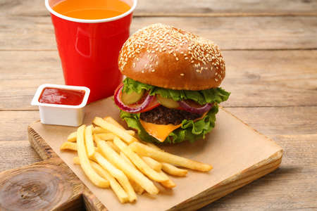 Burger, French fries, ketchup and refreshing drink on wooden table. fast foodの写真素材