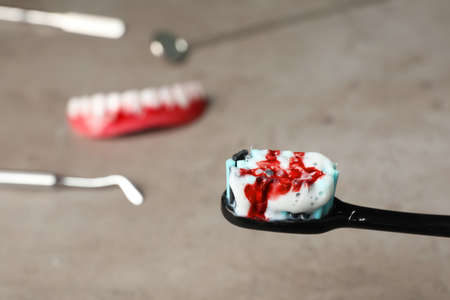 Toothbrush with paste and blood on blurred background, space for text. gum inflammationの写真素材